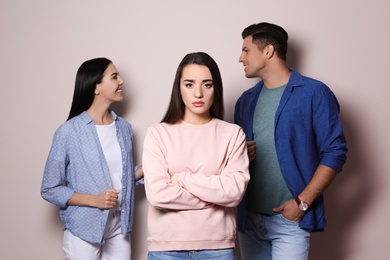 Photo of Unhappy woman feeling jealous while couple spending time together on grey background