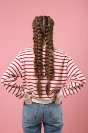 Photo of Woman with braided hair on pink background, back view