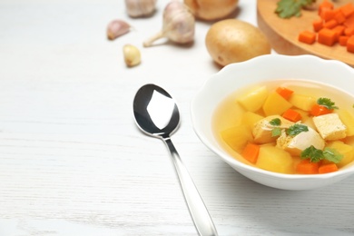 Photo of Dish with fresh homemade chicken soup on wooden table, space for text