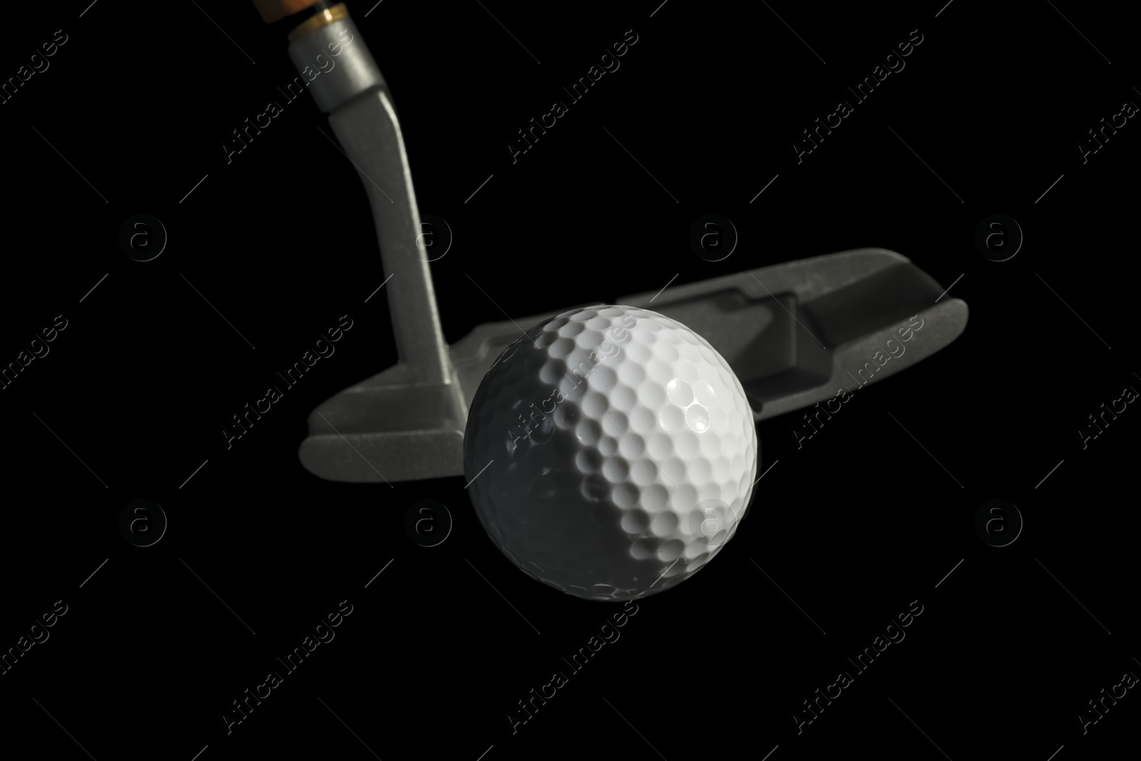 Photo of Golf club and ball against dark background