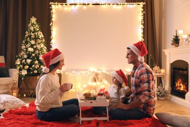 Photo of Family near video projector screen at home. Cozy Christmas atmosphere