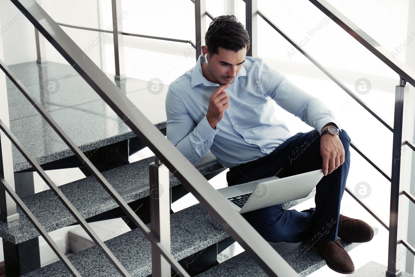 Photo of Portrait of young man with laptop indoors