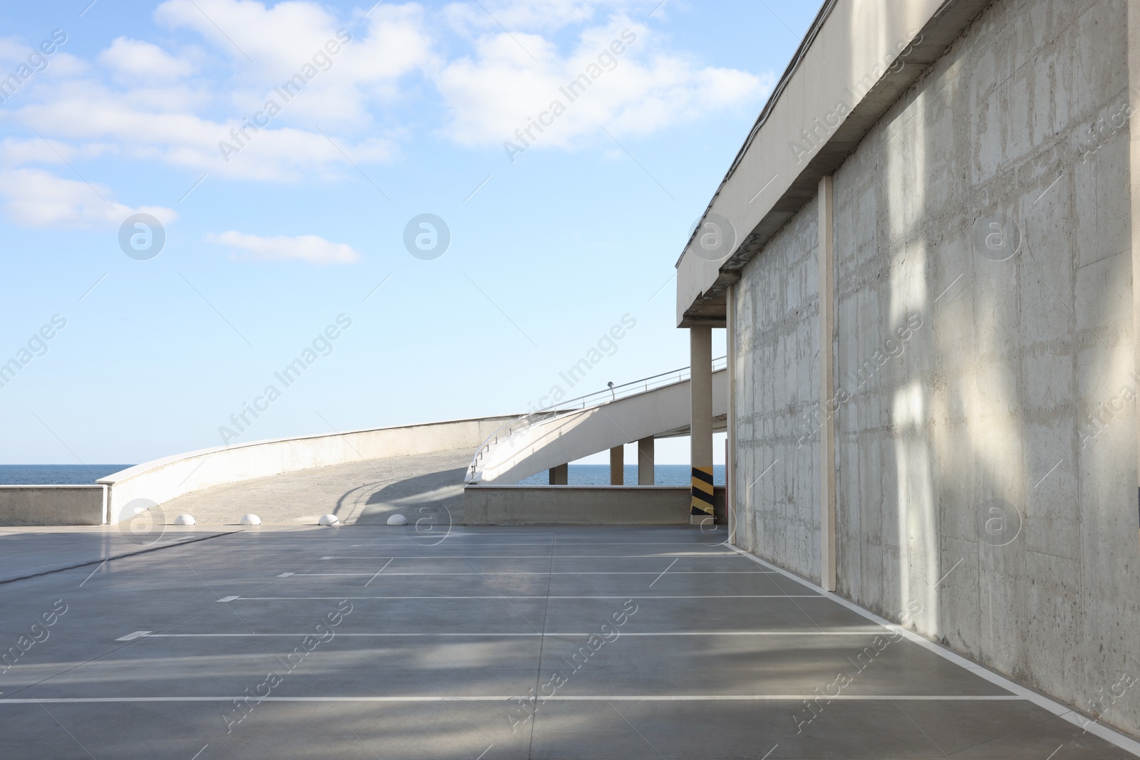 Photo of Empty outdoor car parking lot with ramp on sunny day