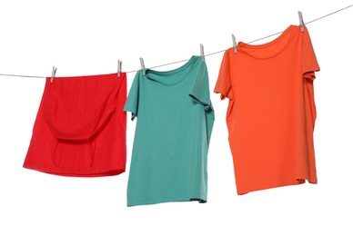 Photo of Different bright clothes drying on washing line against white background