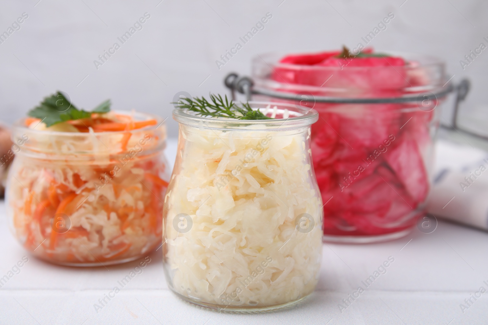 Photo of Delicious sauerkraut prepared according to different recipes on white table, closeup