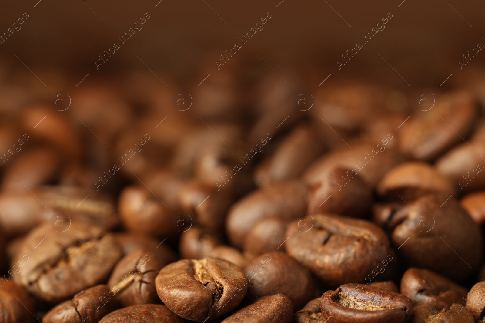 Photo of Heap of aromatic roasted coffee beans, closeup