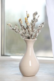 Beautiful pussy willow branches in vase on window sill