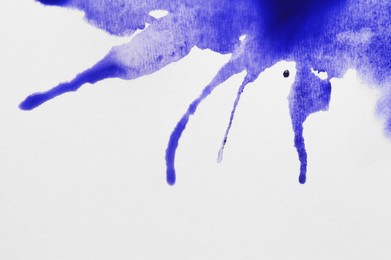 Blue ink blots on white canvas, top view
