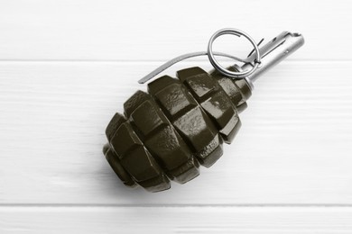 Photo of Hand grenade on white wooden table, top view