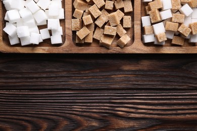 Photo of Tray with brown and white sugar cubes on wooden table, top view. Space for text