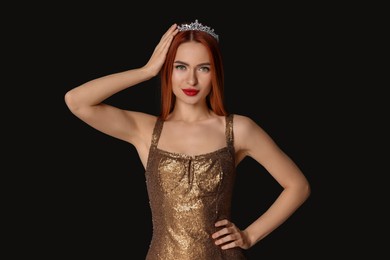 Photo of Beautiful young woman with tiara in dress on black background