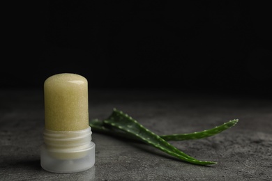 Photo of Natural crystal alum deodorant and aloe on grey table. Space for text