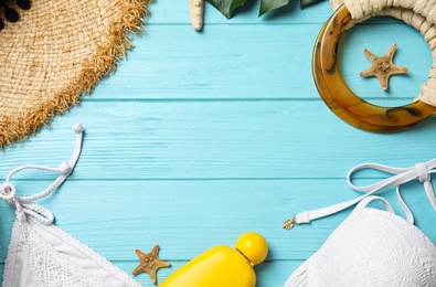 Flat lay composition with beach objects on light blue wooden background. Space for text