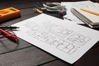 Wiring diagrams, office stationery, wires and digital multimeter on wooden table