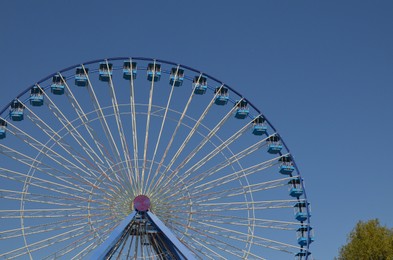 Amusement park. Beautiful large Ferris wheel against blue sky