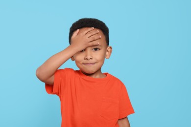 Portrait of emotional African-American boy on turquoise background