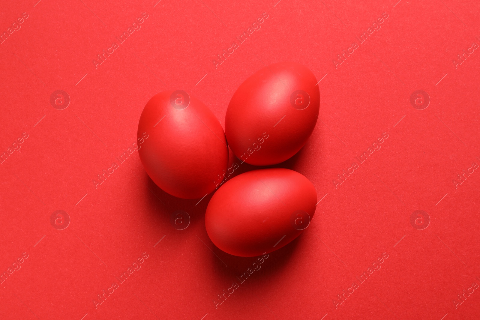 Photo of Flat lay composition of red dyed Easter eggs on color