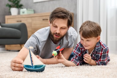 Photo of Dad and son playing toys together at home