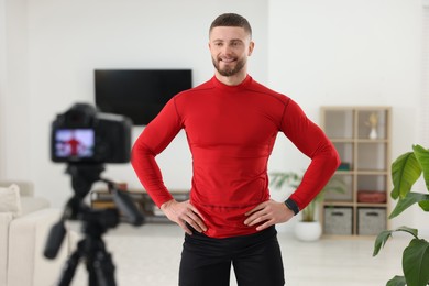 Photo of Trainer recording fitness lesson on camera at home