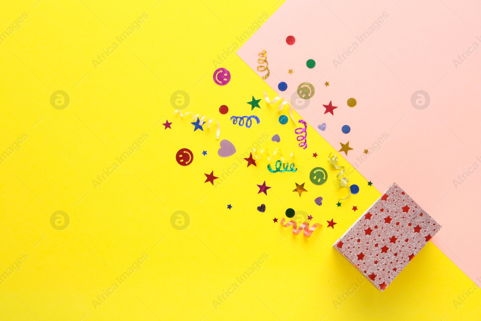Photo of Shiny confetti and box on color background, top view. Space for text