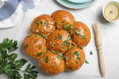 Photo of Traditional Ukrainian garlic bread (Pampushky) on light marble table, flat lay