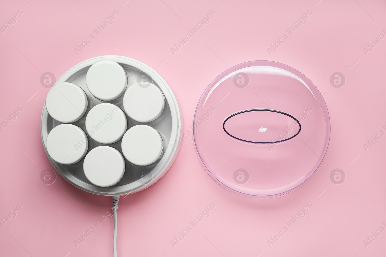 Photo of Modern yogurt maker with jars on pink background, flat lay