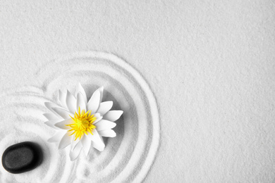 Photo of Zen garden. Beautiful lotus flower, stone and space for text on white sand, flat lay