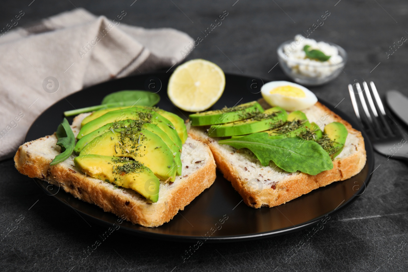 Photo of Tasty avocado toasts served on black table, closeup