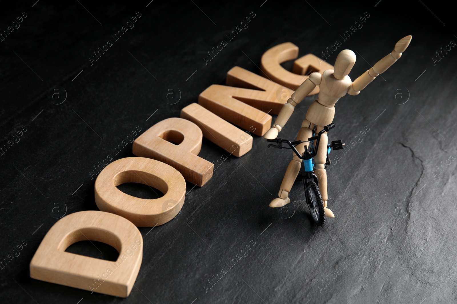 Photo of Word Doping, sportsman and bicycle model on black background