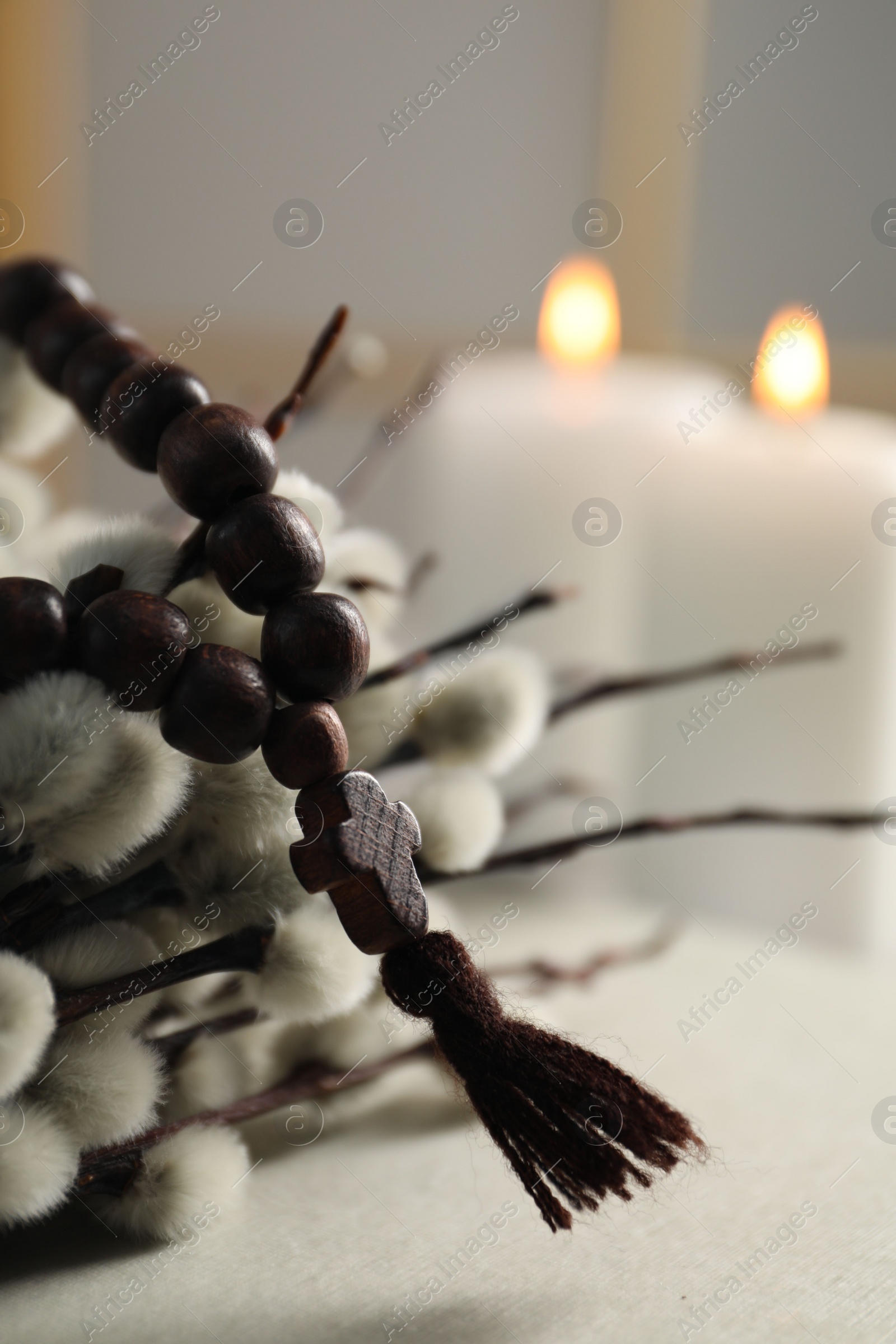 Photo of Rosary beads and willow branches on table, closeup