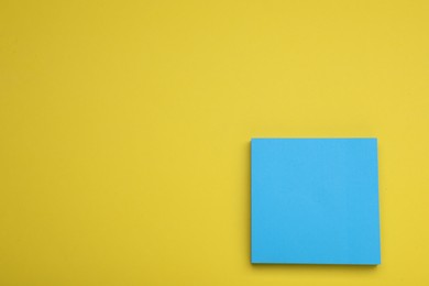 Photo of Paper note on yellow background, top view. Space for text