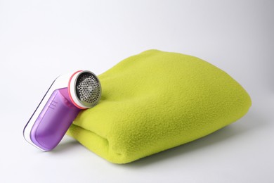 Photo of Fabric shaver and woolen cloth with lint on white background