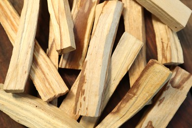 Photo of Many palo santo sticks on wooden table, closeup