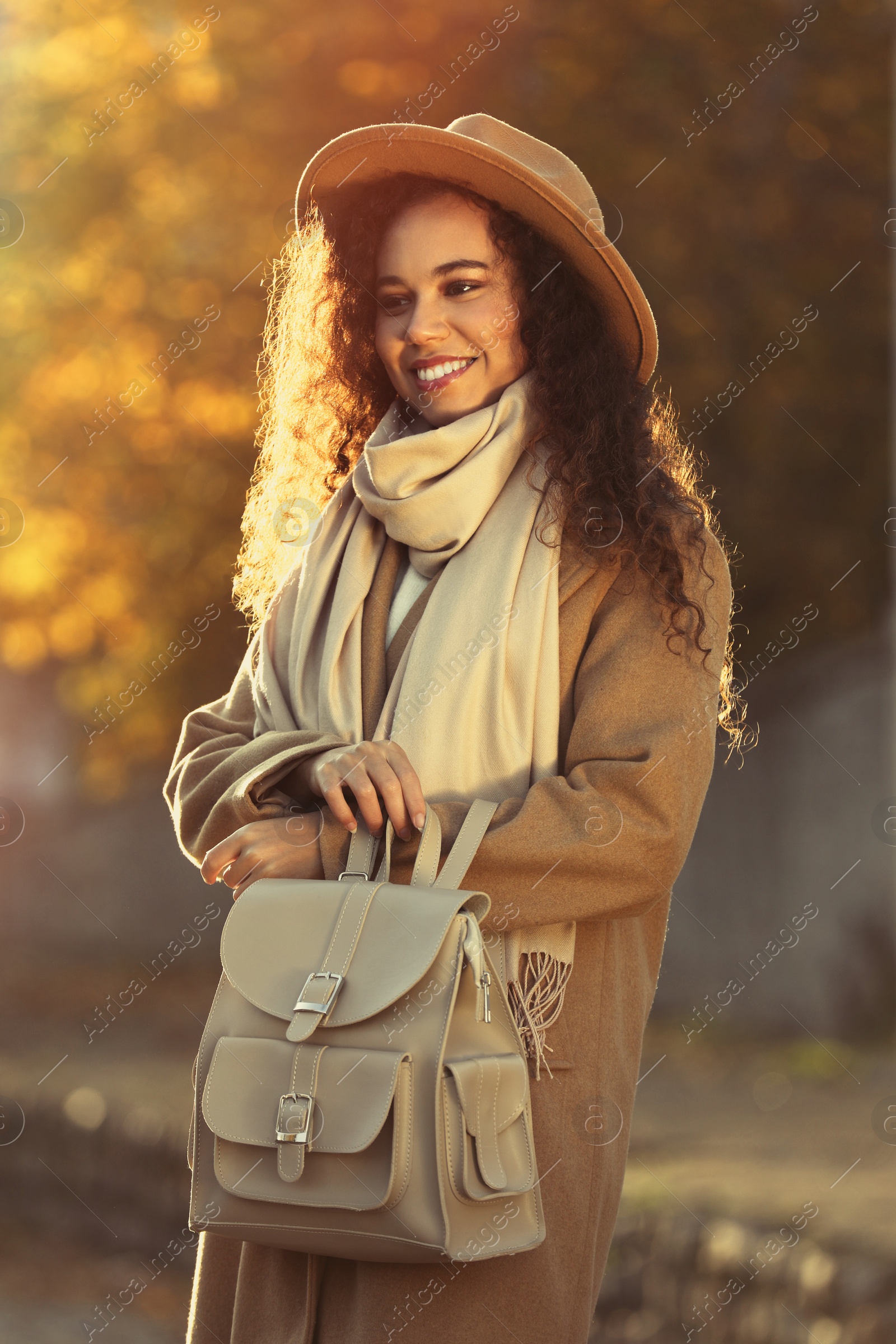 Photo of Portrait of beautiful African-American woman with stylish beige backpack on city street