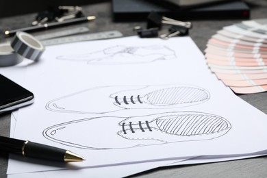 Photo of Drawing of shoes on table, closeup. Designer's workplace