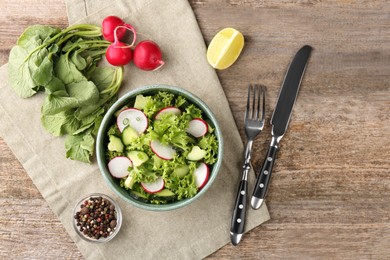 Photo of Delicious salad with radish served on wooden table, flat lay