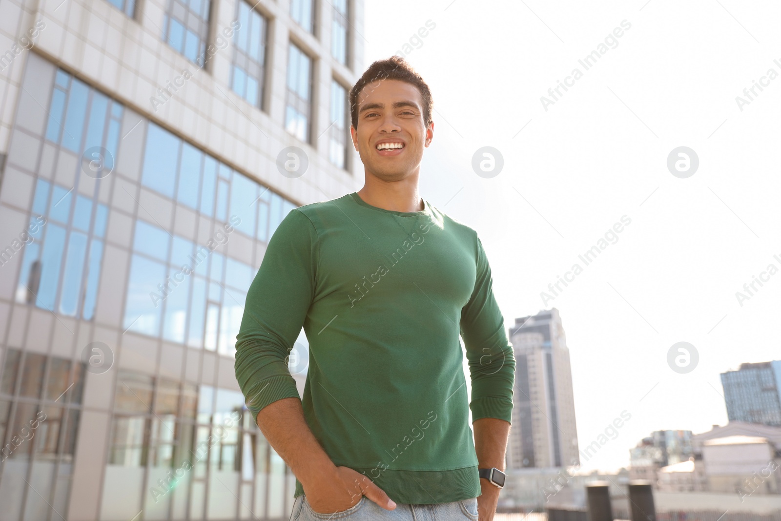 Photo of Portrait of handsome young African-American man on city street, low angle view