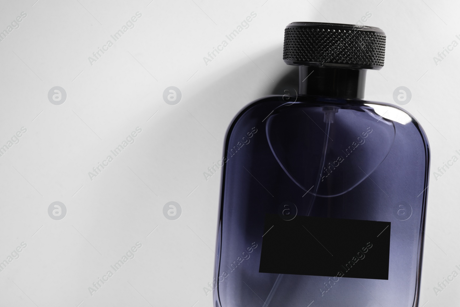 Photo of Luxury men`s perfume in bottle on white background, top view. Space for text