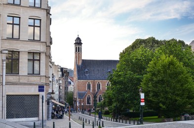 Photo of City street with beautiful buildings and green trees