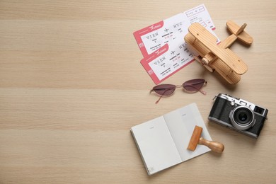 Photo of Flat lay composition with passport, stamp and flight tickets on wooden table, space for text