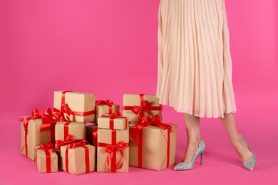 Photo of Woman and gift boxes on pink background, closeup. Black Friday Sale