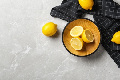 Flat lay composition with lemons and fabric on light background