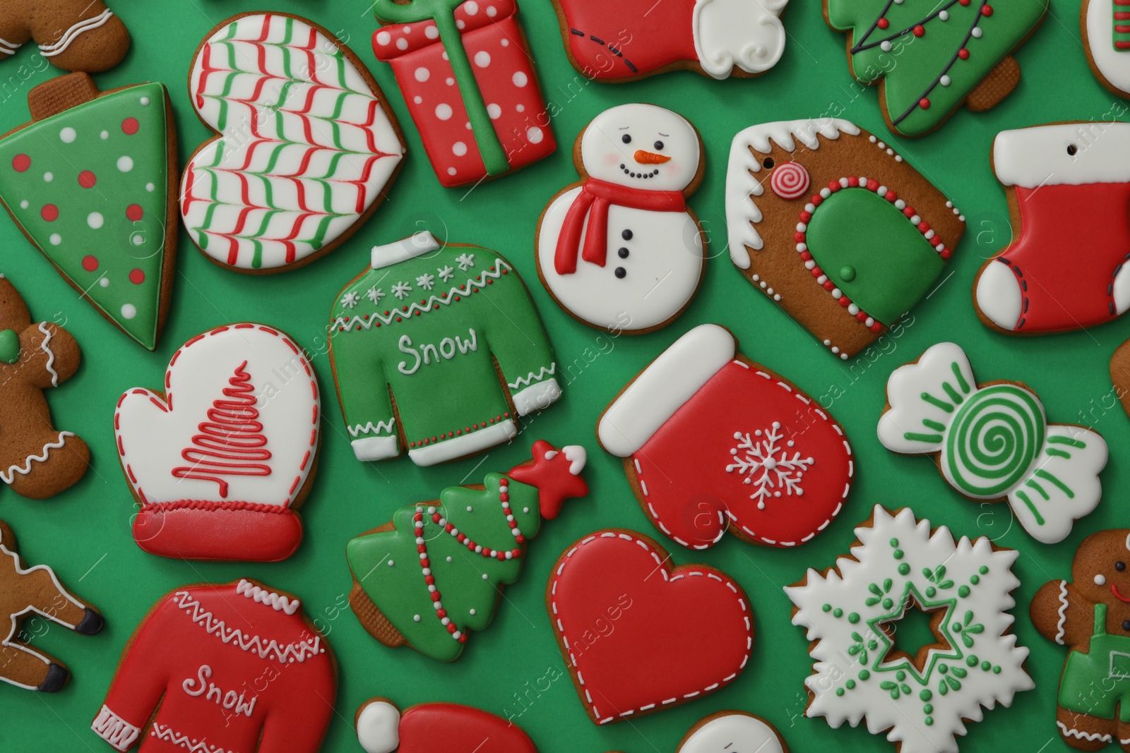 Photo of Different Christmas gingerbread cookies on green background, flat lay