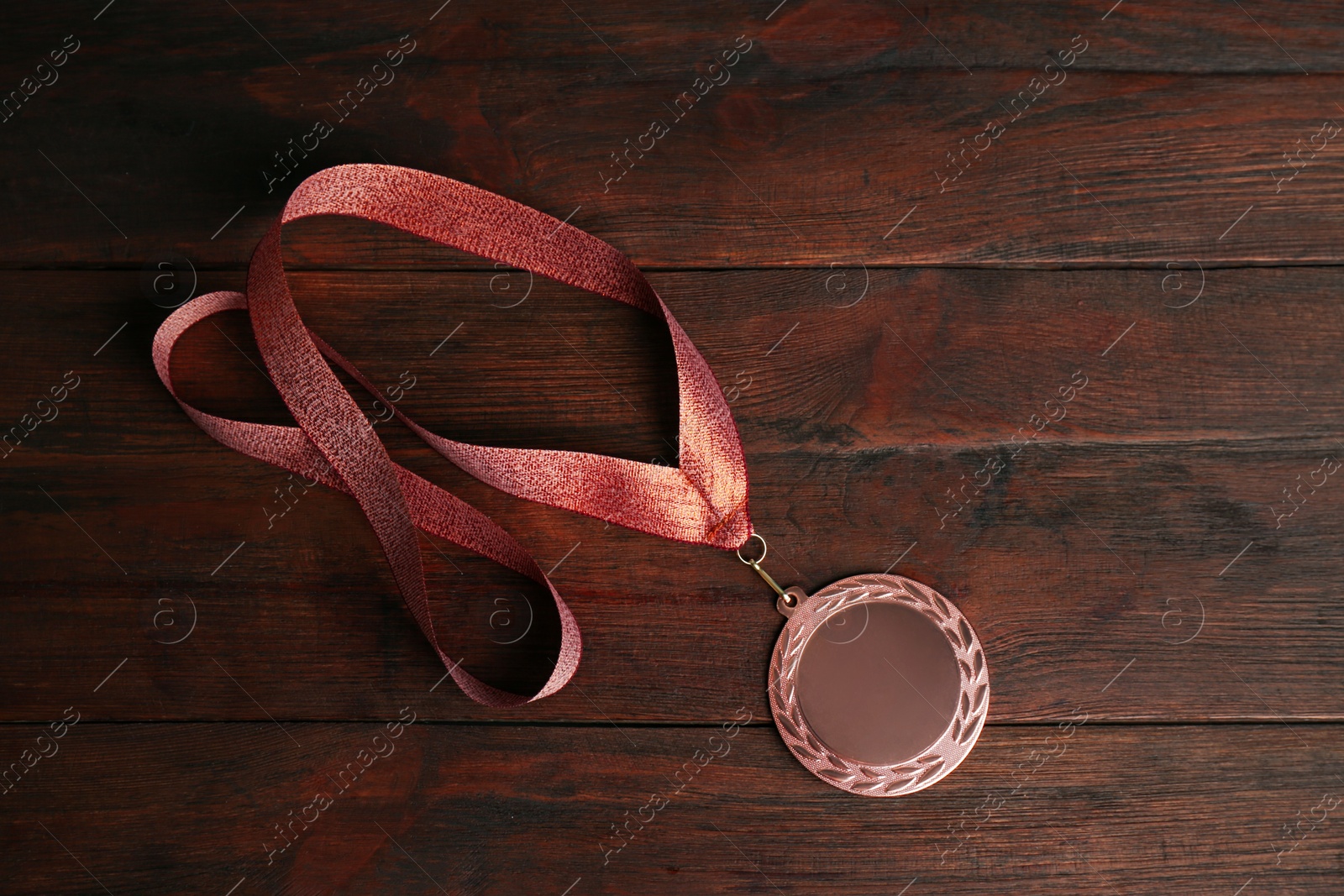 Photo of Bronze medal on wooden background, top view. Space for design