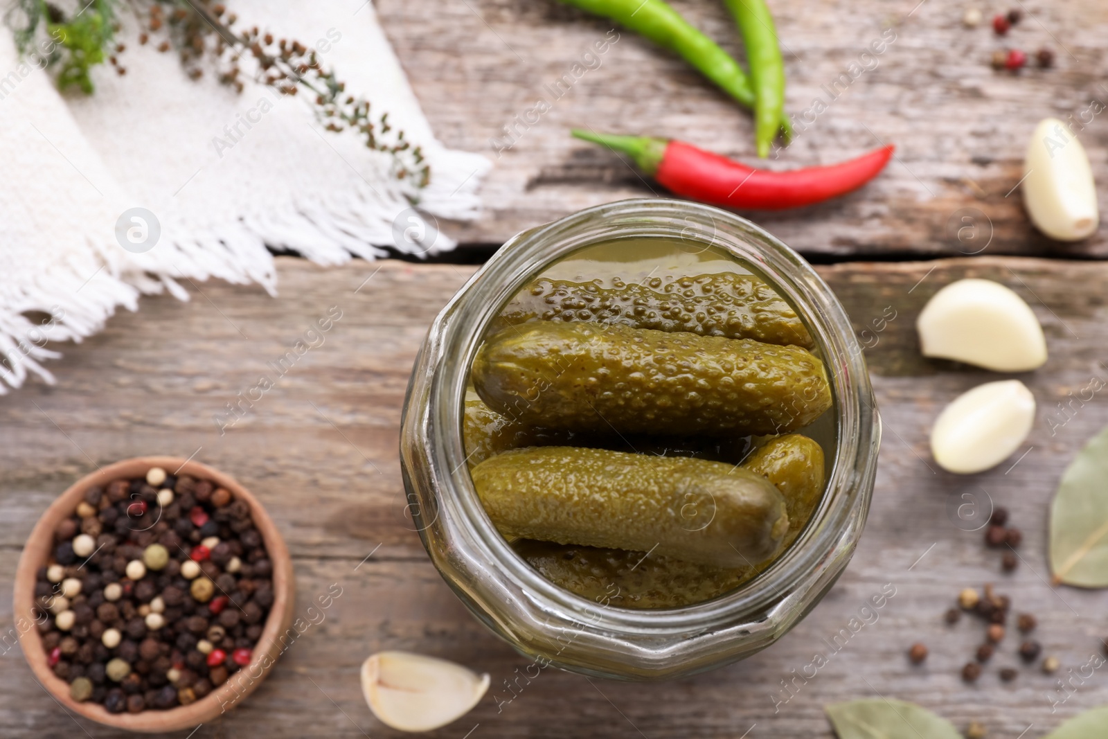 Photo of Tasty pickled cucumbers and ingredients on wooden table, flat lay