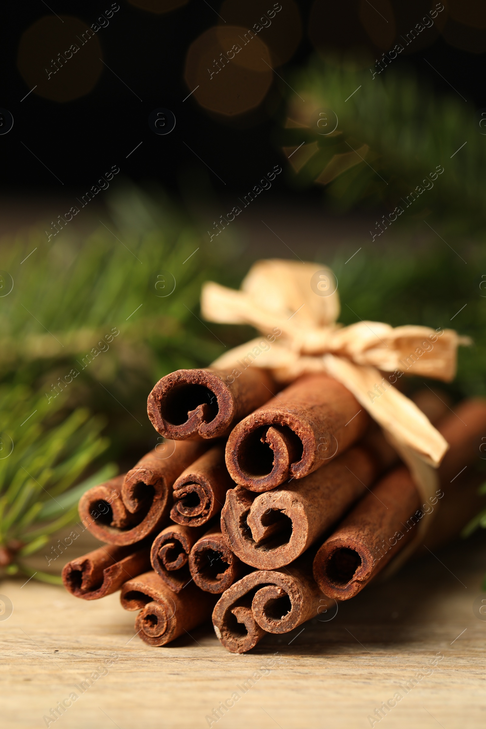 Photo of Bunch of cinnamon sticks on wooden table, closeup