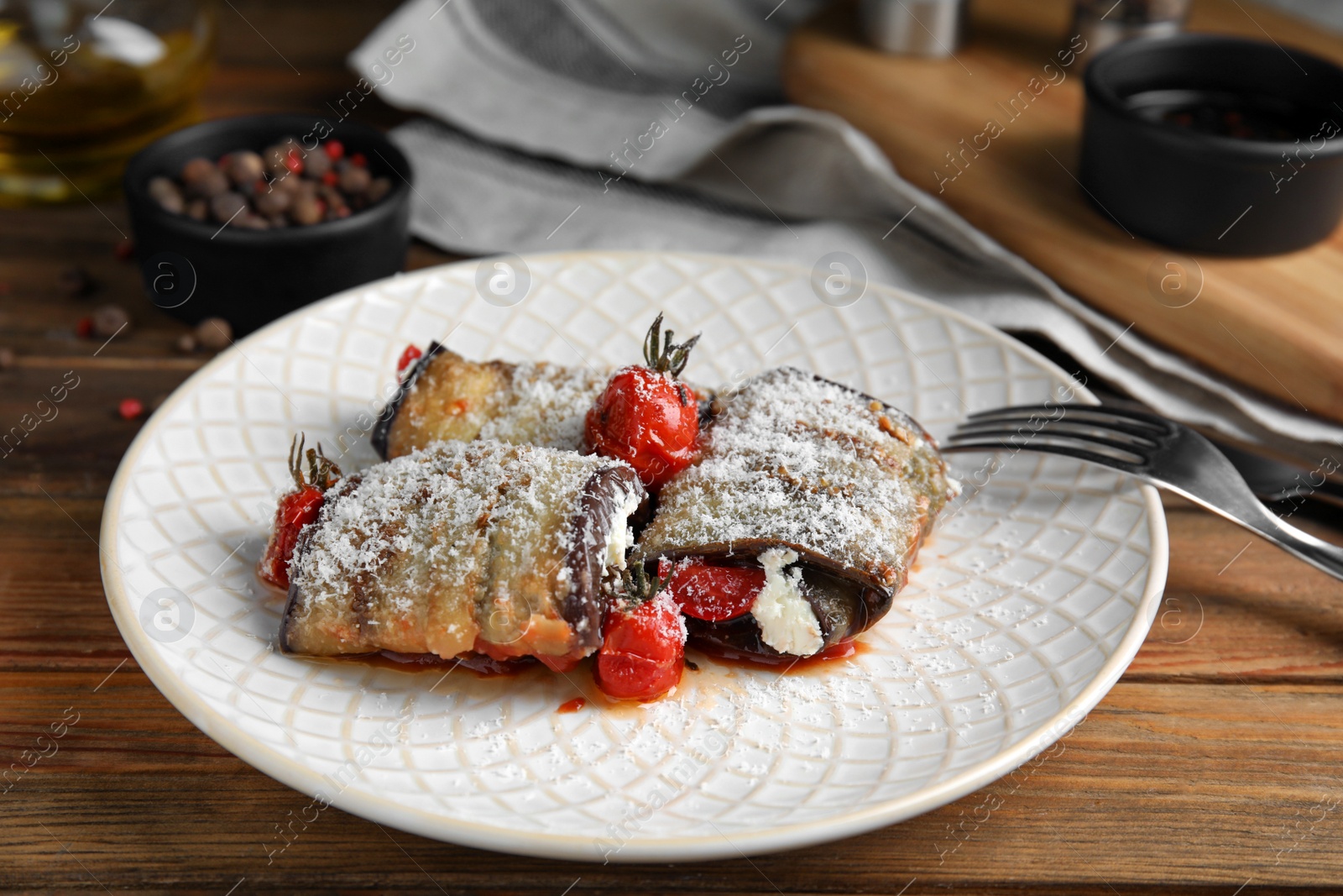 Photo of Delicious baked eggplant rolls served on wooden table