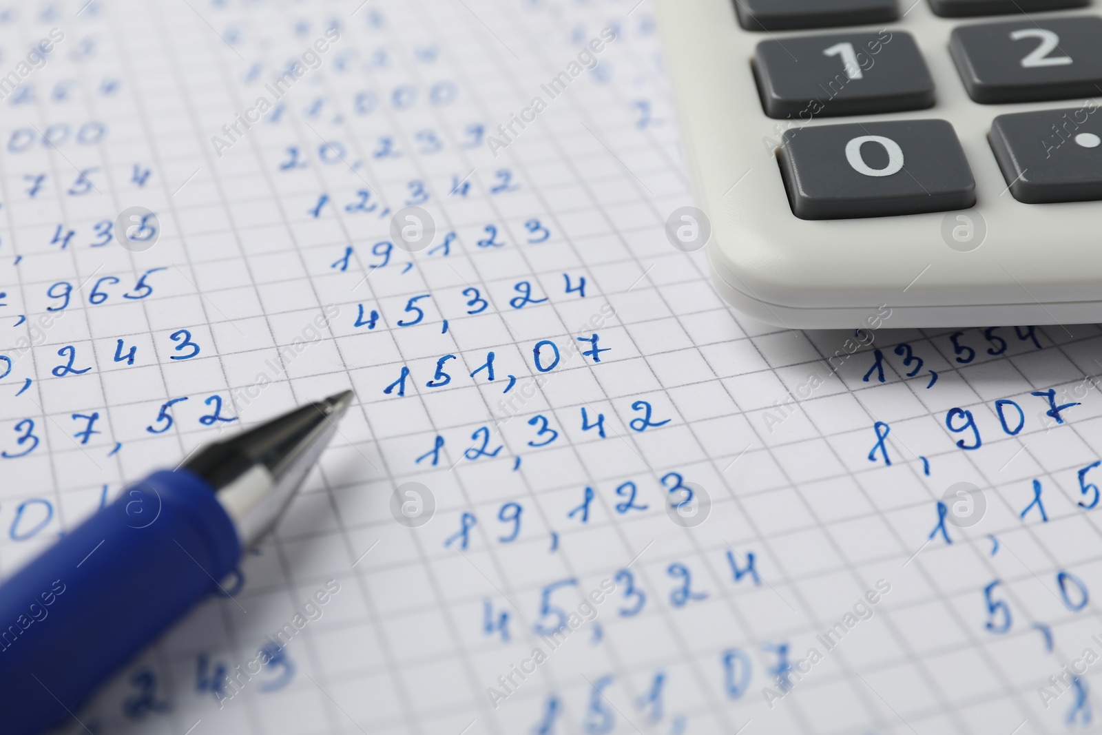 Photo of Calculator and pen on document with data, closeup view