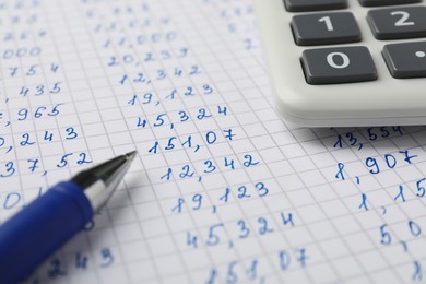 Photo of Calculator and pen on document with data, closeup view