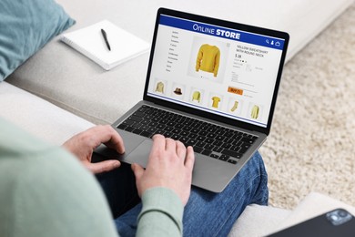 Photo of Man with laptop shopping online indoors, closeup